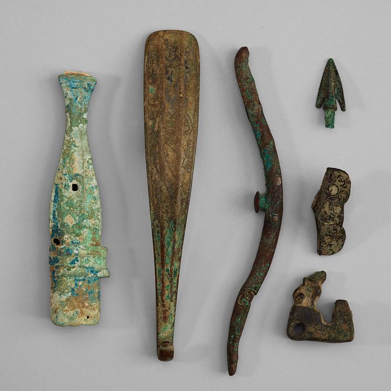 A set with six archaic bronze belthooks and armoury parts, Zhou-/Han dynasty.