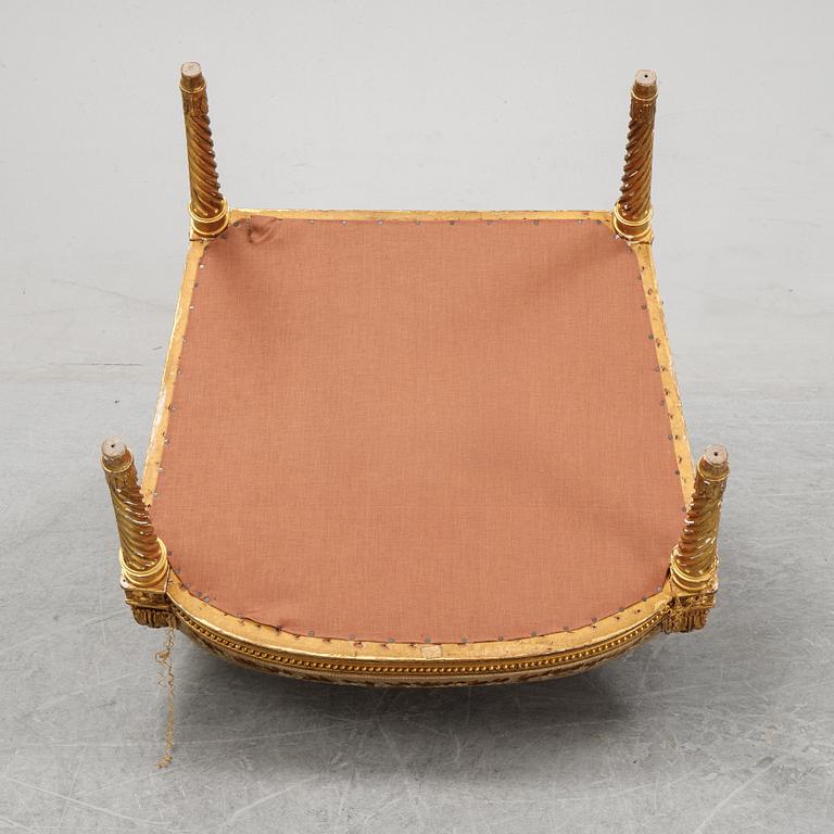 A gilt Louis XVI style armchair from around the year 1900.