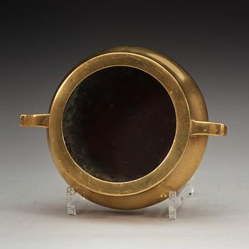 A polished bronze tripod censer, Ming dynasty (1368-1644).