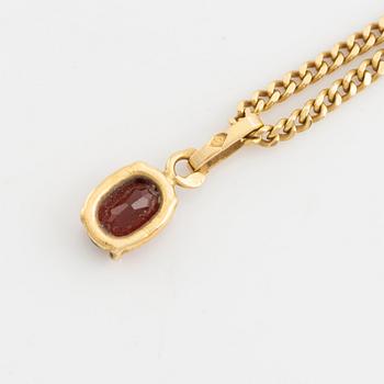 Pendant with chain with red stone, possibly garnet.