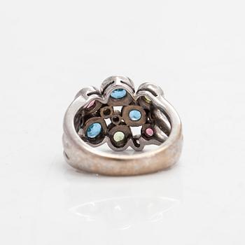 Cassandra Goad, sormus, "Cirkel", 18K valkokultaa, timantteja noin 0.08 ct ja monivärisiä jalokiviä. Lontoo.
