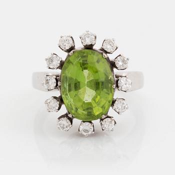 400. An 18K white gold ring set with a faceted peridot and round brilliant-cut diamonds.