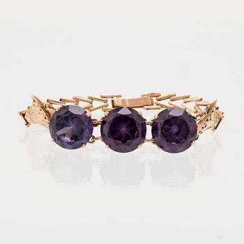 Bracelet, ring, and brooch in gold with synthetic colour-changing sapphires and glass.