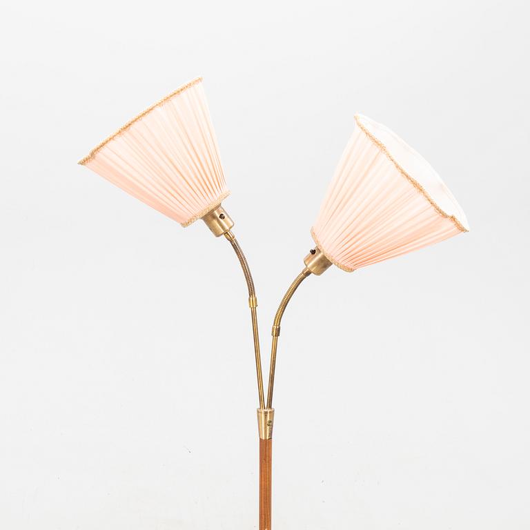 A teak and brass floor lamp from the first half of the 20th century.