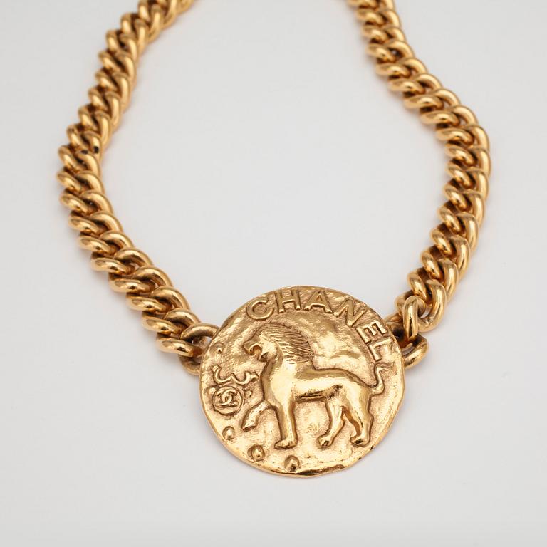 CHANEL, a gold colored chain necklace with medallion.