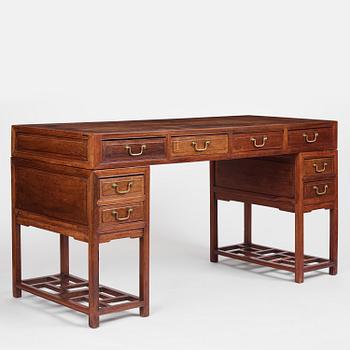 A six-drawer 'jichimu' pedestal partners desk, late Qing dynasty/early 20th century.