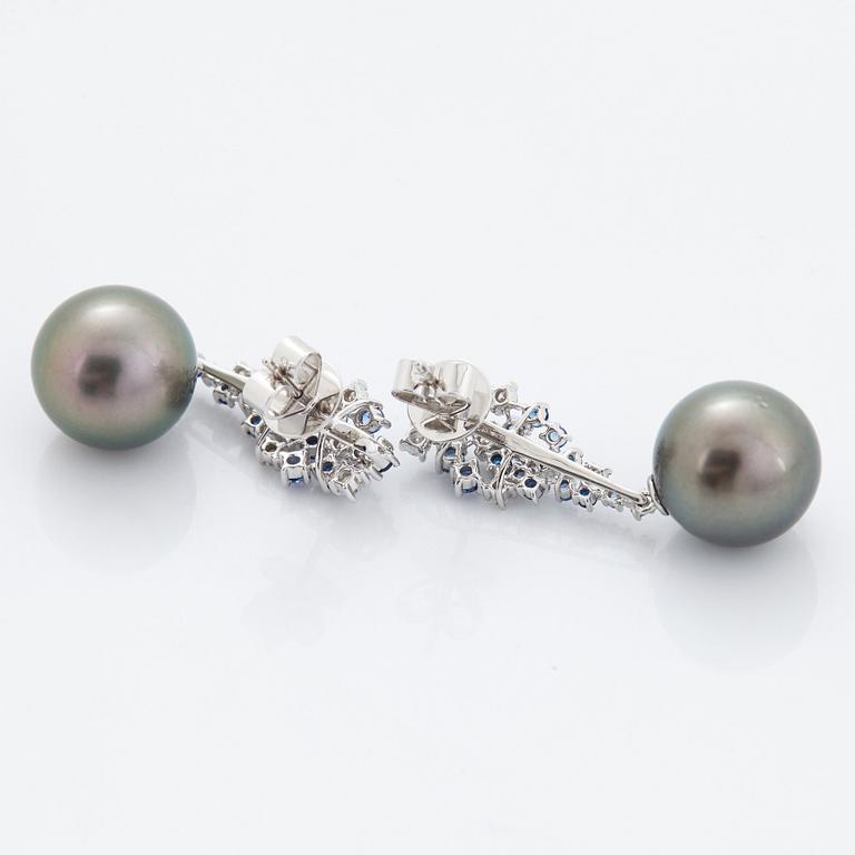 A pair of 18K white gold earrings set with Tahitian cultured pearls and round brilliant-cut diamonds.