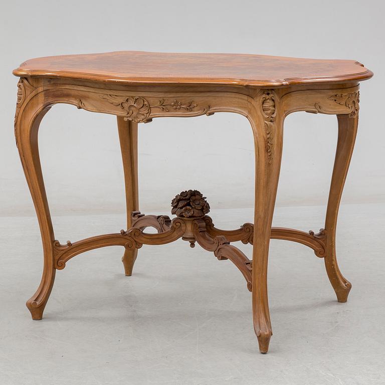 An end of the 19th Century rococo style walnut sofa with four chairs, two armchairs and a table.