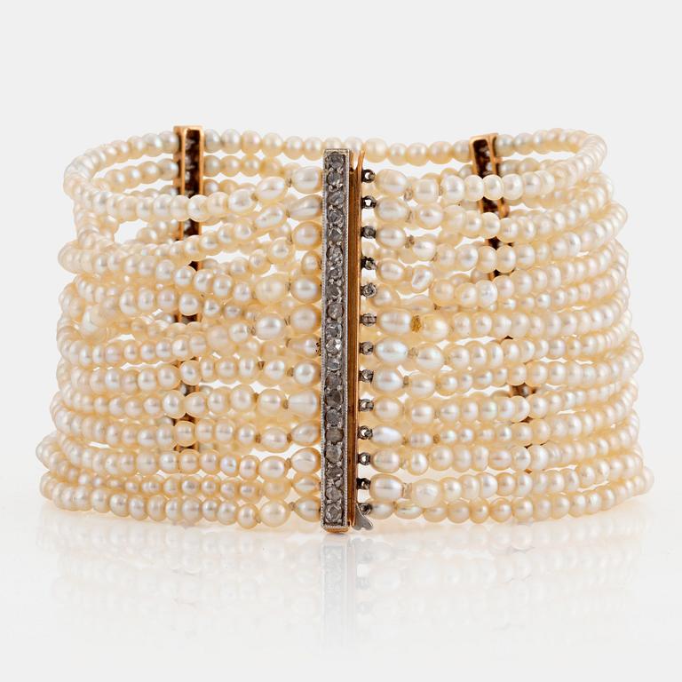 A pearl bracelet with a clasp and dividers in 14K gold and platinum set with rose-cut diamonds.