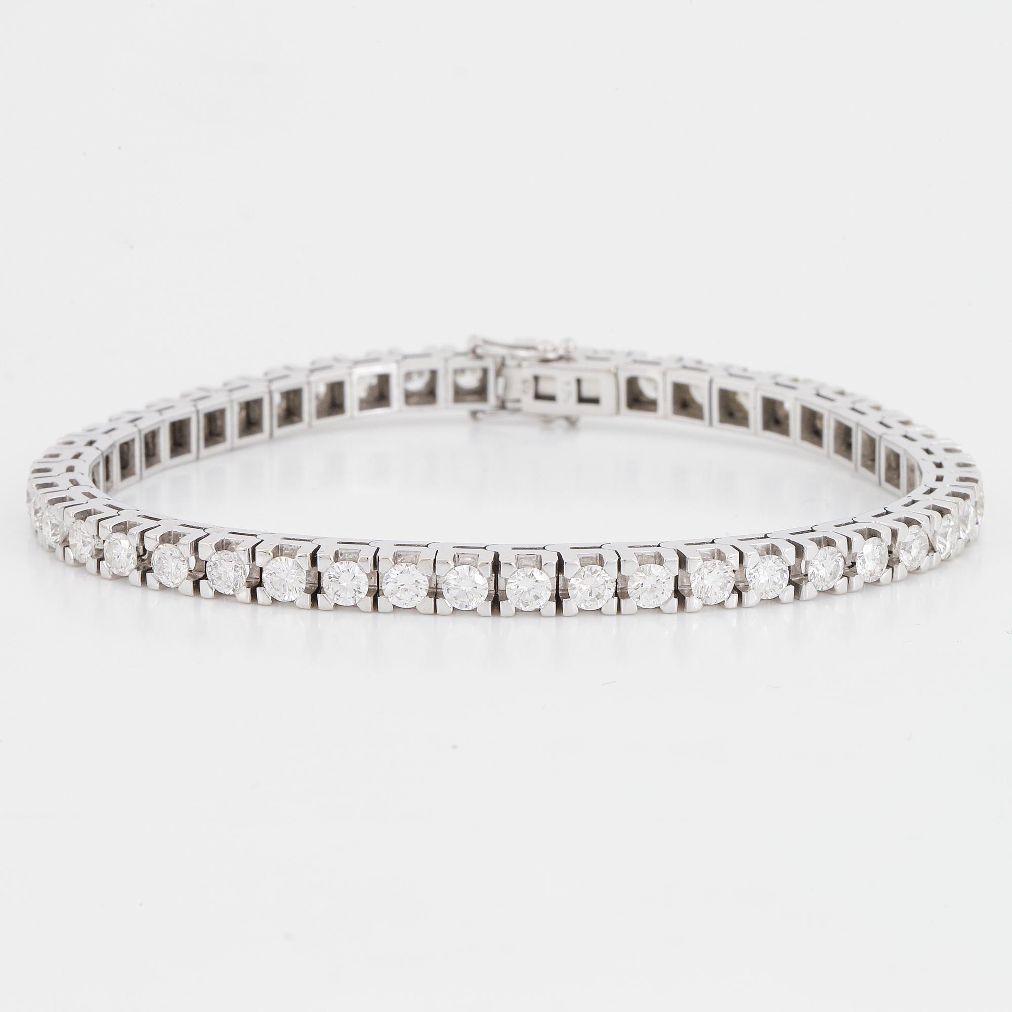 An 18K white gold tennisbraclet set with round brilliant-cut diamonds.