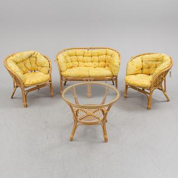 A 1970s four piece set of rattan garden furniture.