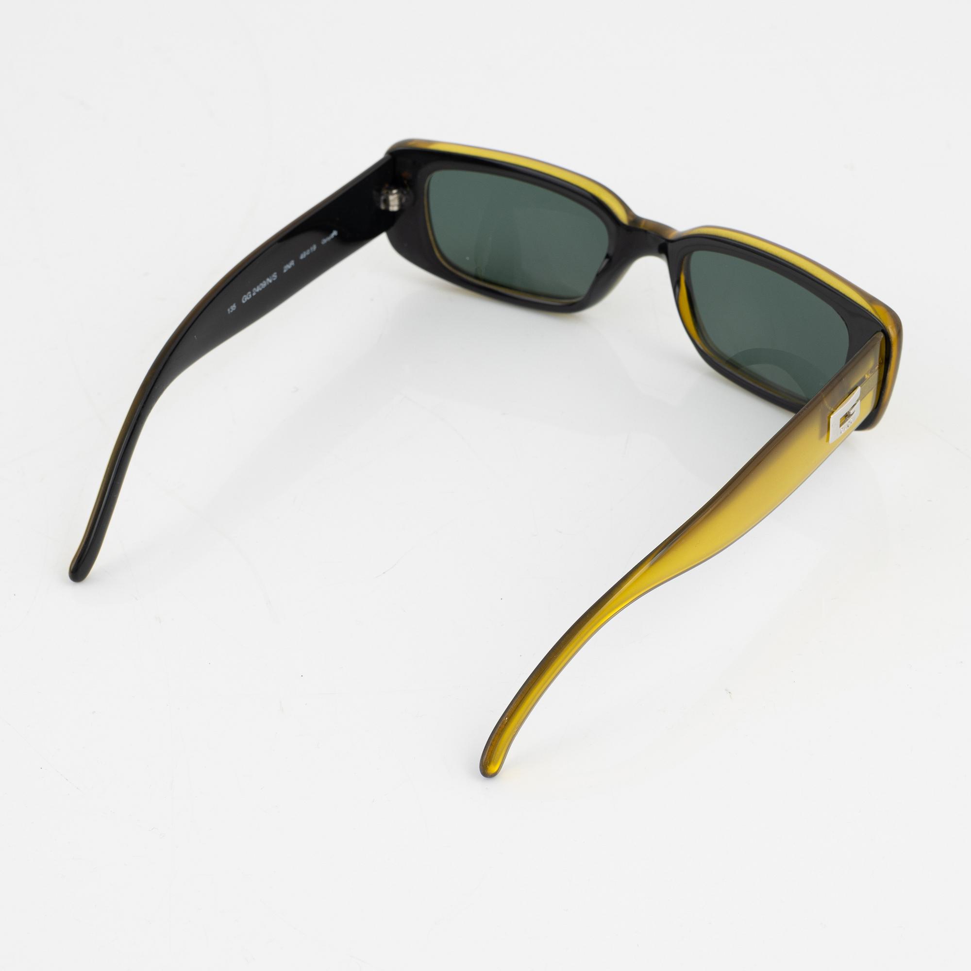 Gucci, a pair of yellow sunglasses.