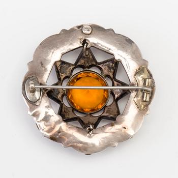 A BROOCH set with amber-coloured paste, heliotrope and jasper.