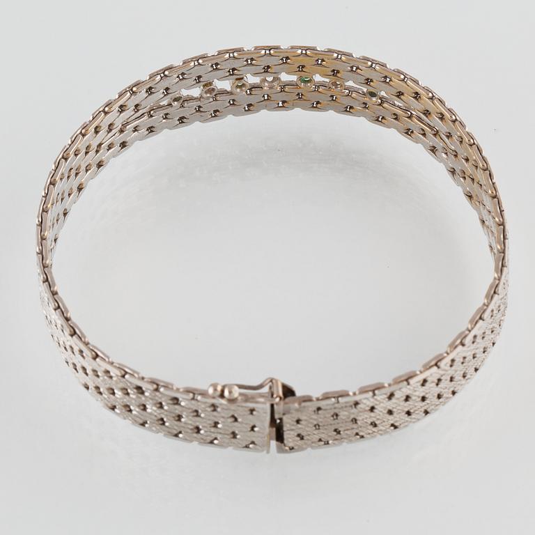 ARMBAND, 18K vitguld med en briljantslipad och 2 åttkantslipade diamanter samt 4 fasettslipade smaragder. Vikt 35,5 gram.