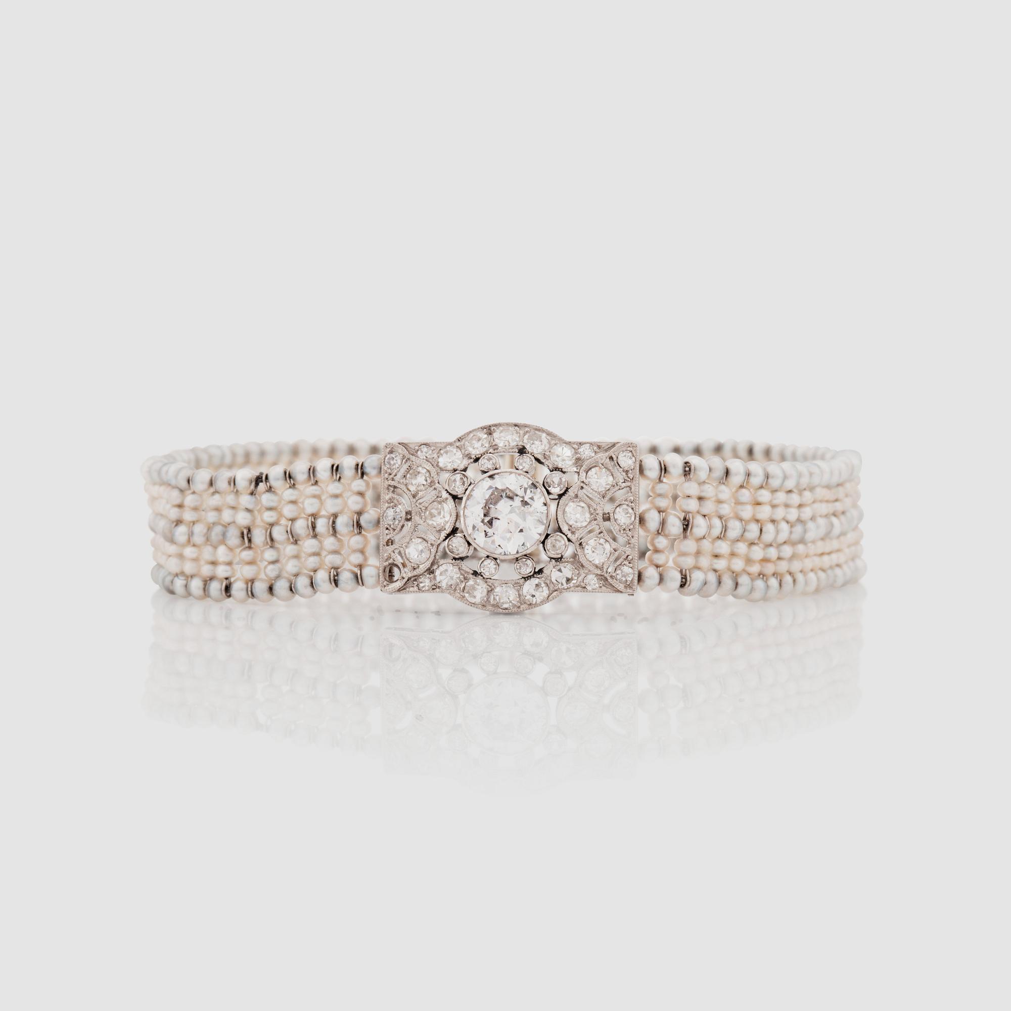 ARMBAND med gammalslipad diamant ca 0.90 ct, orientaliska pärlor samt mindre diamanter, totalt ca 1.00 ct. Ca. 1920-tal.
