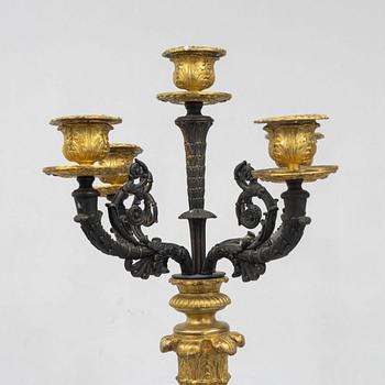 A pair of French Empire-style patinated and gilt bronze five-light candelabra, later part 19th century.