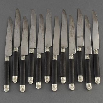 A set of twelve French 19th century ebony with silver dinner-knifes, unmarked.