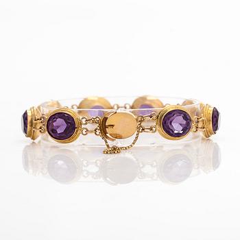 A ca. 15K gold bracelet with oval faceted synthetic sapphires.