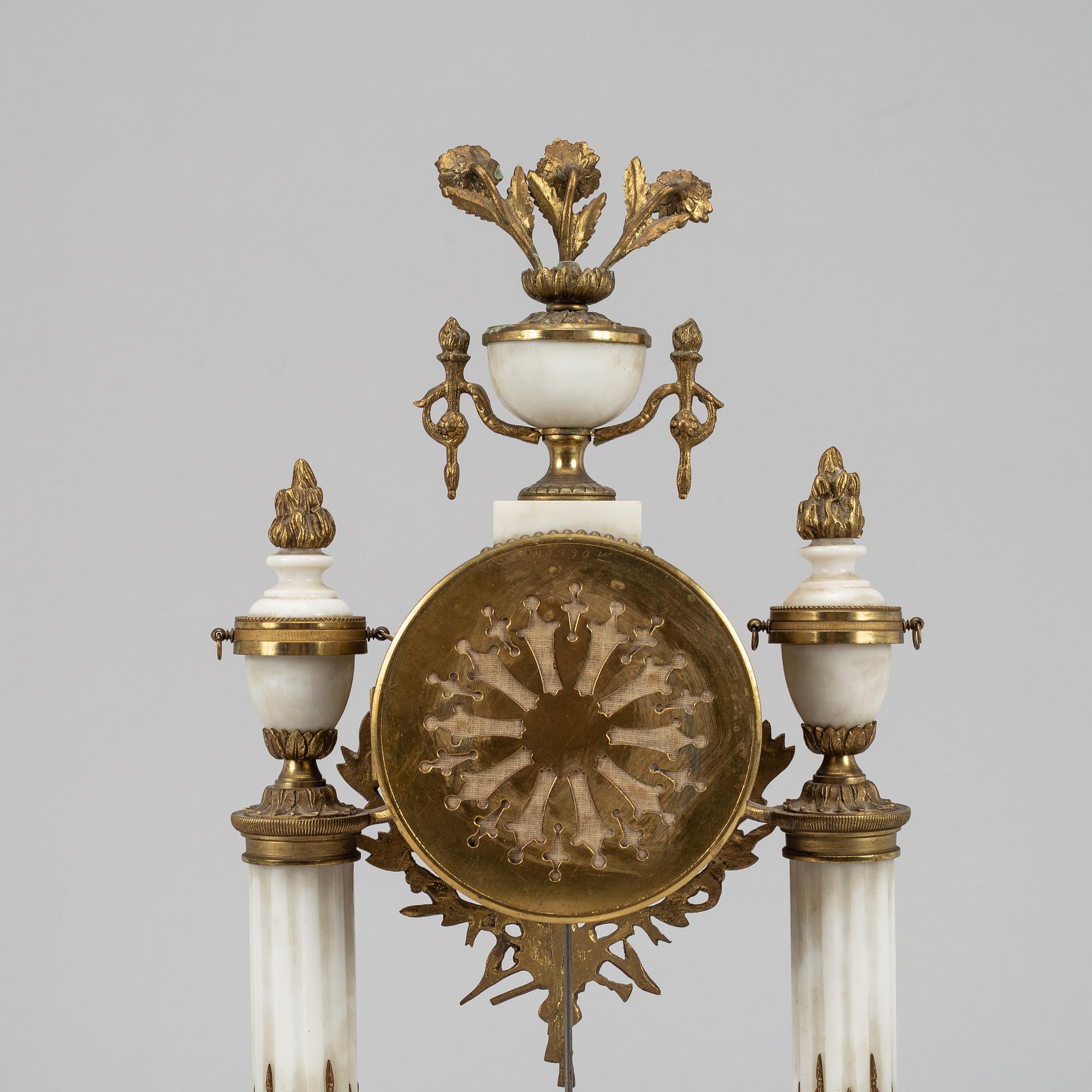 A Louis XVI style pendulum clock and a pair of candelabra, early 20th century.
