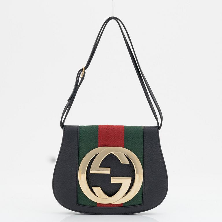 Gucci, a black leather and gold logo bag.