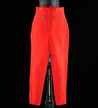 A pair of orange trousers by Hermès.