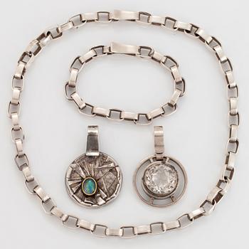 Sven Erik Högberg garnityr två hängen, ett armband och en collier.