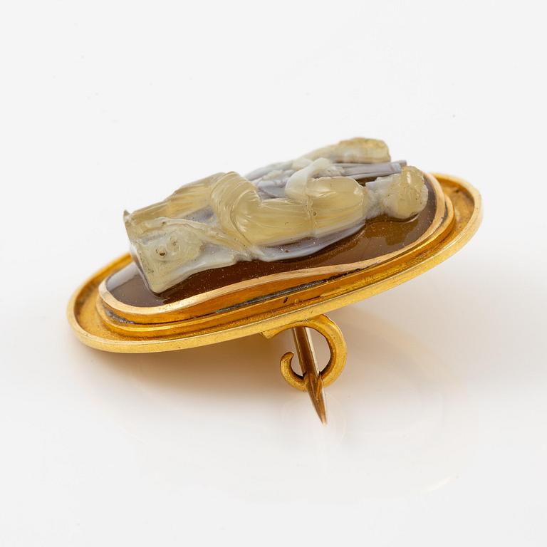 A brooch in 18K gold with a hardstone cameo.