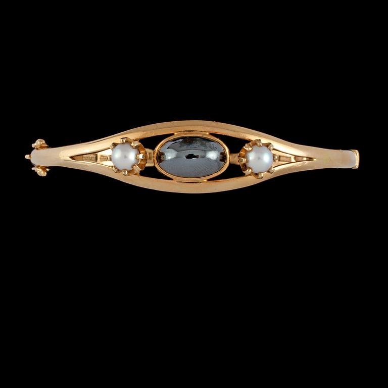 ARMRING, 18K guld med 2 odlade pärlor samt cabochonslipad hematit. Vikt 22,3 g.