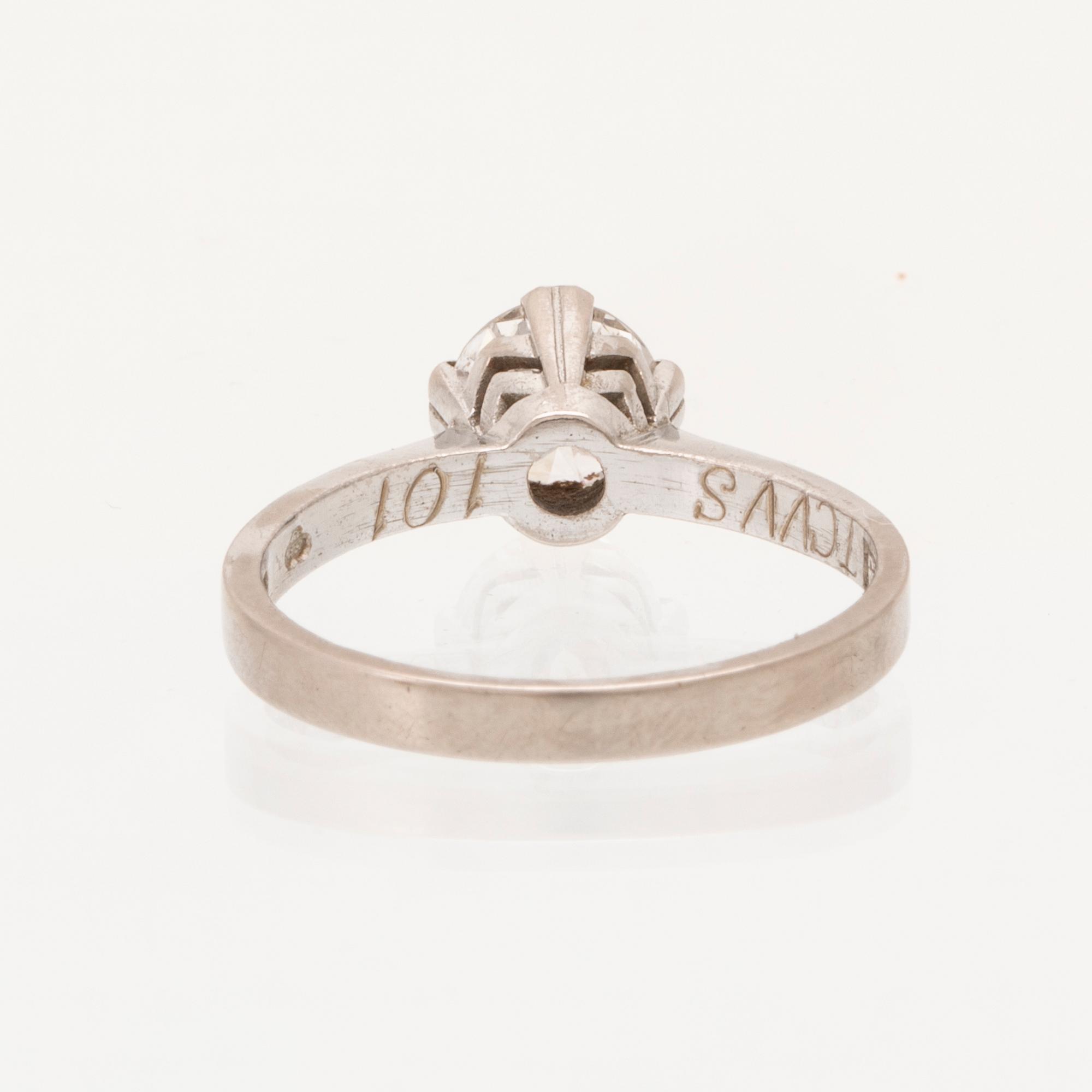 An 18K white gold solitaire ring set with a round brilliant cut diamond.