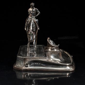 SKRIVSTÄLL med jockeyn Fred Archer till häst. Vitmetall. Sannolikt England, sent 1800-tal.