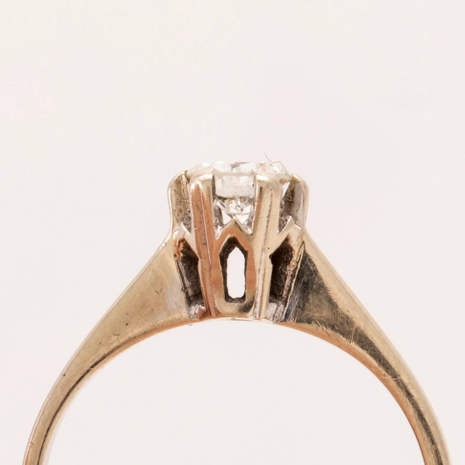 An 18K white gold solitaire ring set with a round brilliant-cut diamond.