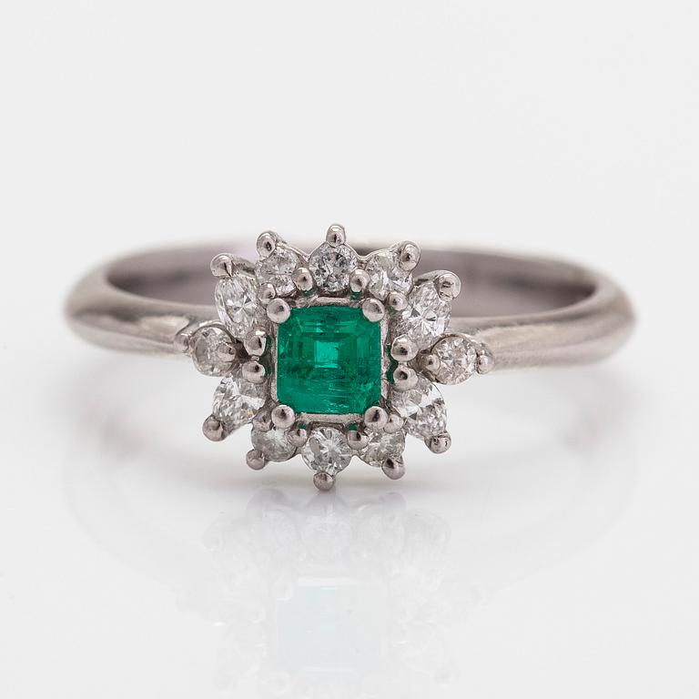 A platinum ring, with an emerald and brilliant- and marquise-cut diamonds.