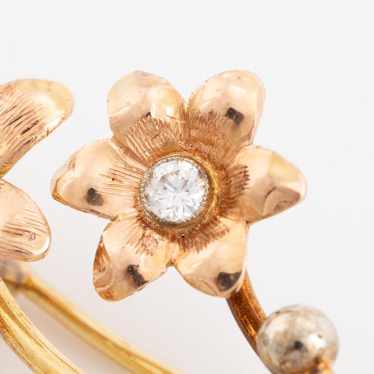 Brosch, guld, blomkvist med briljantslipade diamanter.