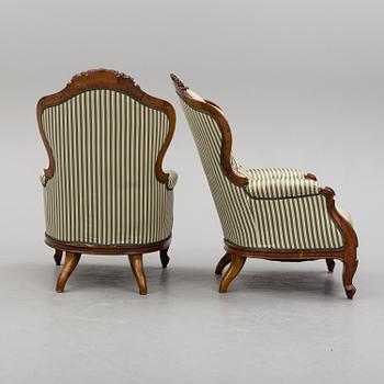 A pair of late 19th century rococo style easy chairs.