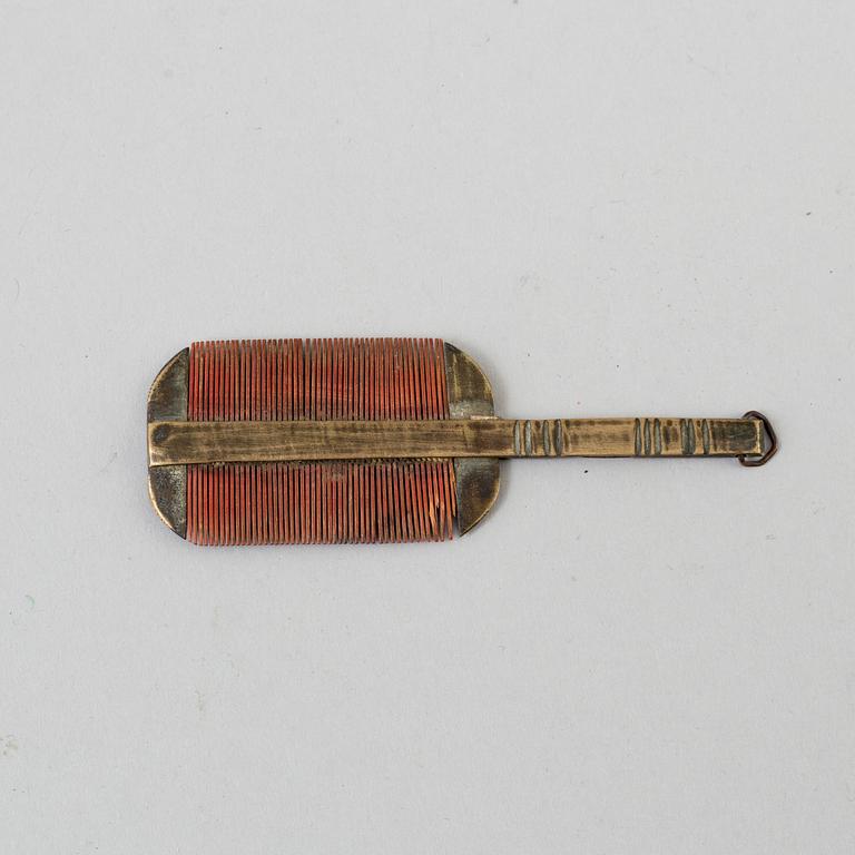 A 18th century brass comb.