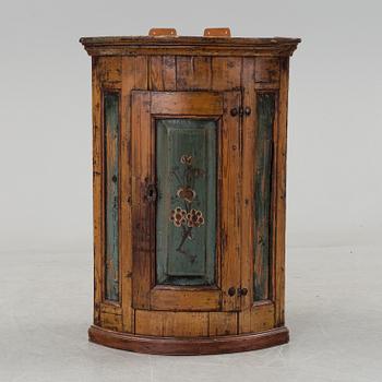 A painted folk art corner hanging cabinet, ca 1800.