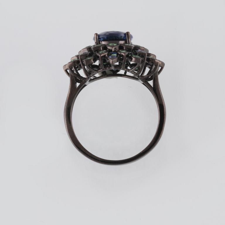 RING, 18K guld med fasettsliapde blå safirer ca 0.18 ct, kyanit ca 2.88 ct samt demantoider ca 0.60 ct. Vikt 6,2 gram.