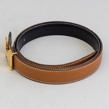 A Hermès "H" belt buckle with reversible leather strap noir/gold.