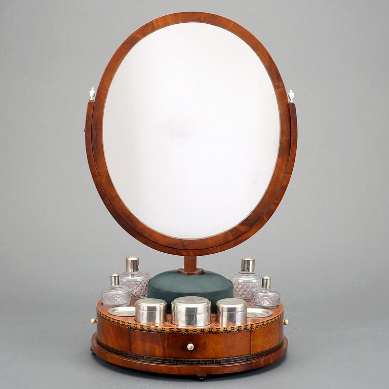 A Swedish Empire circa 1820 mirror on a stand for silver and glass toiletries.