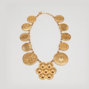 YVES SAINT LAURENT, a gold colored medallion necklace.