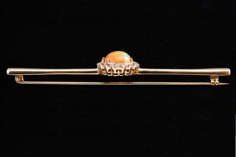 BROSCH, Briljantslipade diamanter ca 0.65 ct, Opal 10 mm.
14K guld. Ostämplad. Längd 85 mm, vikt 8,2 g.
