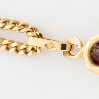 Pendant with chain with red stone, possibly garnet.