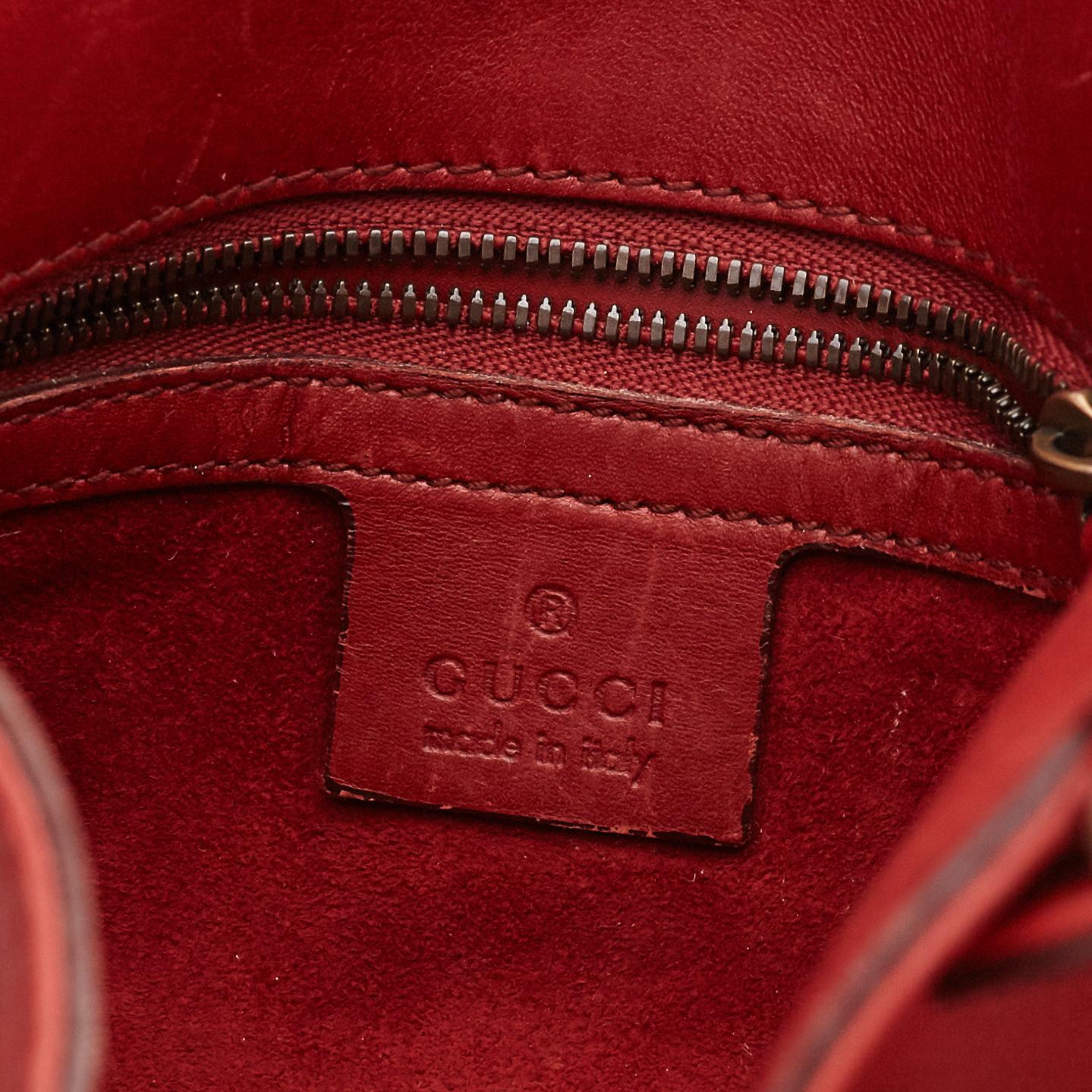 GUCCI, a red leather crossbody bag.