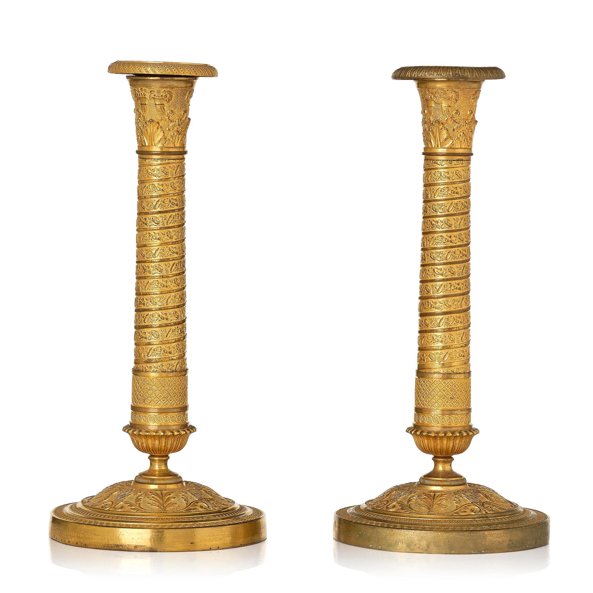 A pair of French Empire ormolu candlesticks, early 19th century.