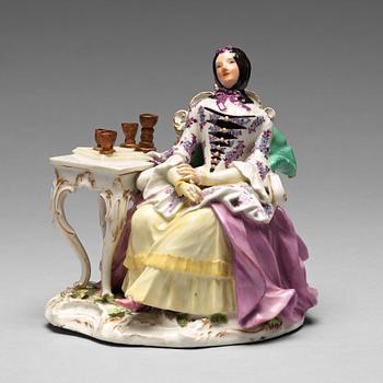 237. A Meissen porcelain figure of a lady by a table.