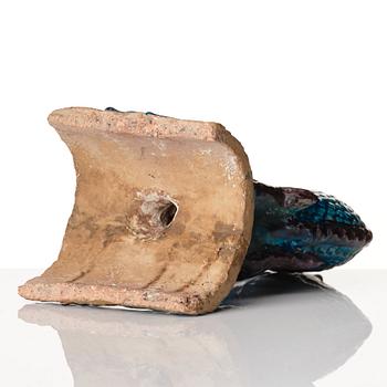 A turkoise and abuergine glazed roof tile in the shape of a fish, Ming dynasty (1368-1644).