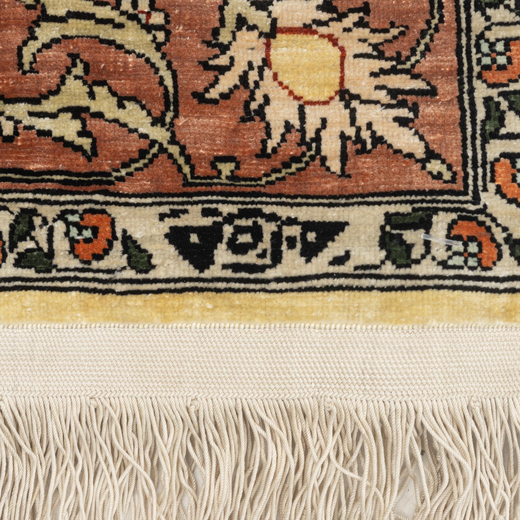 A silk Hereke rug, c. 77 x 53 cm.