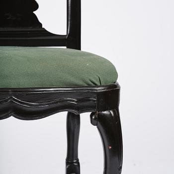 A set of eight black Swedish rococo chairs.