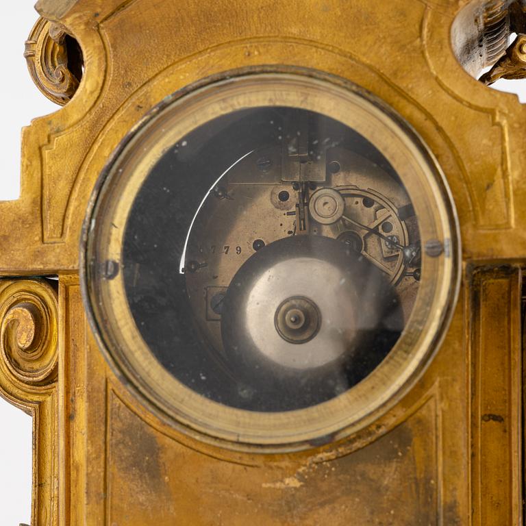 A French mantel clock, two urns and two depicters, second half of the 19th Century.