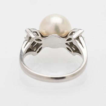 Platinum ring with a cultured pearl, emeralds and diamonds.